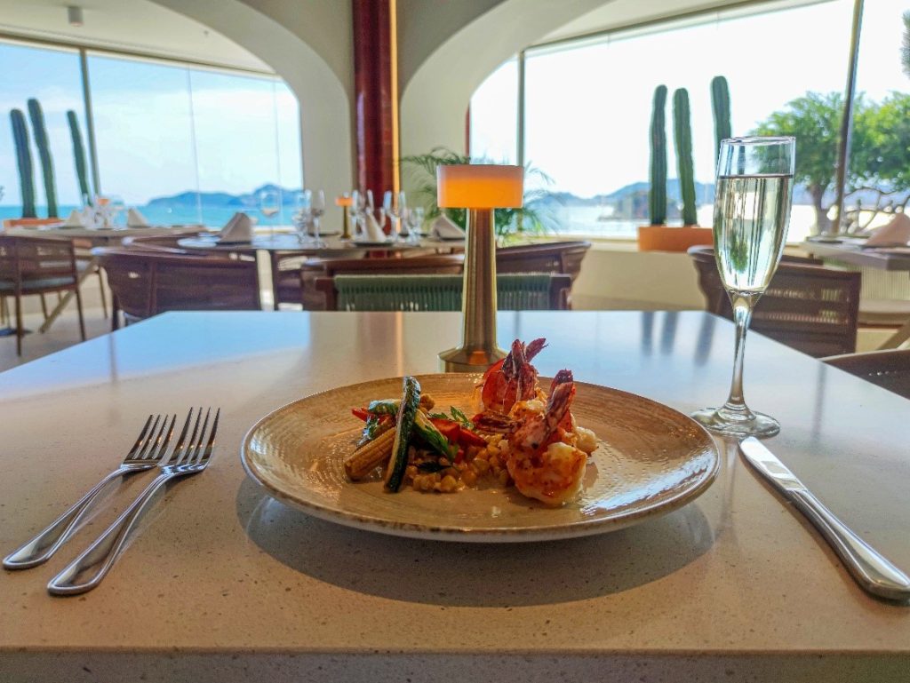 Camarones al Mezcal, flambeados y servidos con esquite cremoso y vegetales.